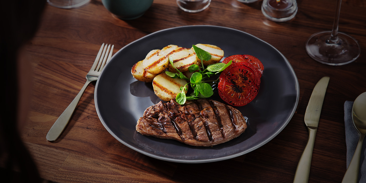 Lamb steak with grilled tomatoes and potatoes