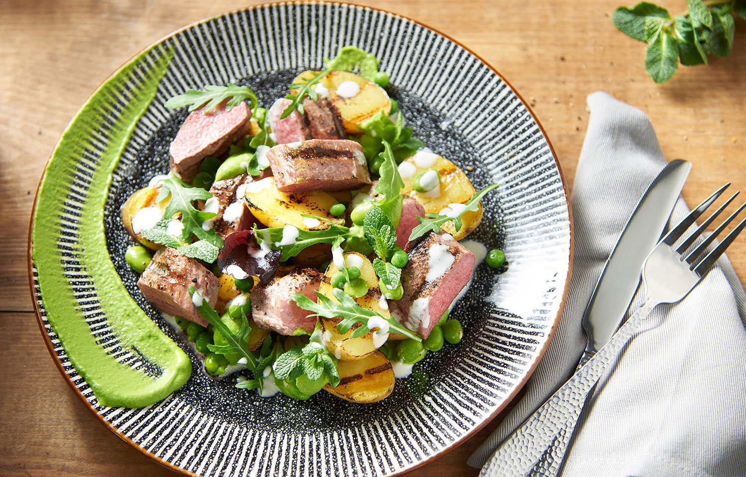 Cordero asado y ensalada de patata con guisantes y menta